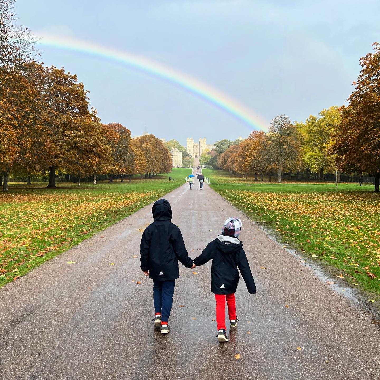 Ein Paar, das auf dem Long Walk im Great Park in Richtung Windsor Castle geht