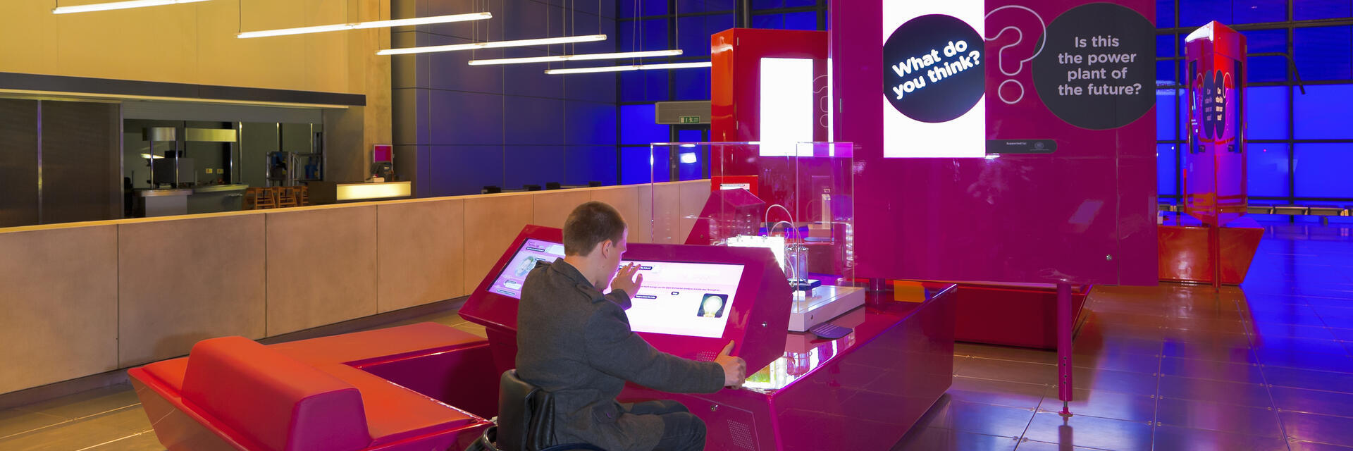 Man in a wheelchair using an interactive display in a museum