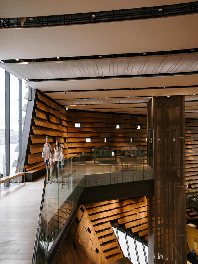 رجل وامرأة وفتاتان يمشون داخل متحف حديث.