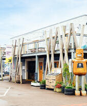 Robot sculpture outside a building with geometric decor