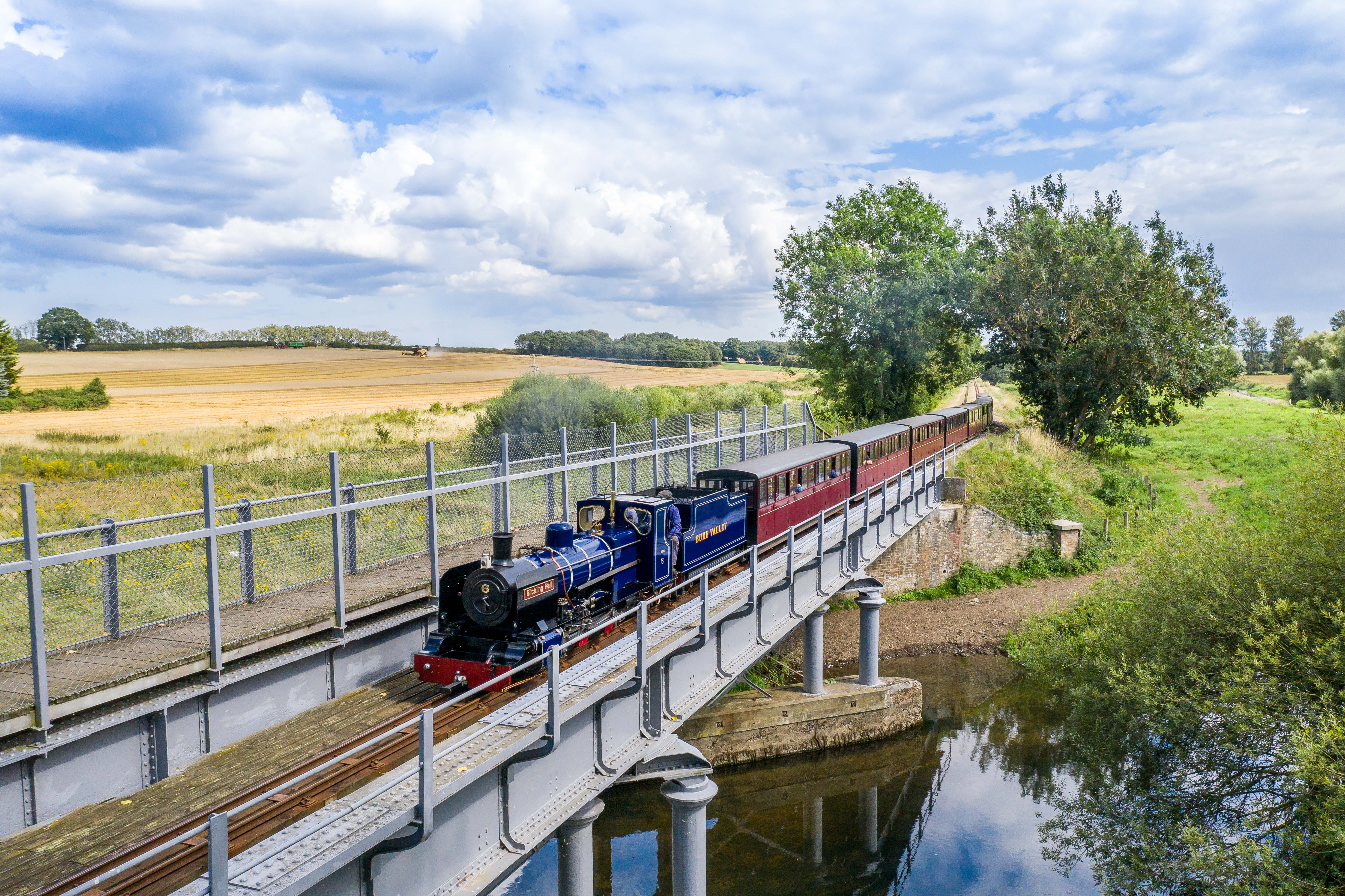 Un train à vapeur passant au-dessus d'une rivière dans le parc national des Broads