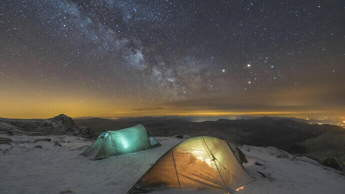 Deux tentes éclairées à l'intérieur. Neige au sol