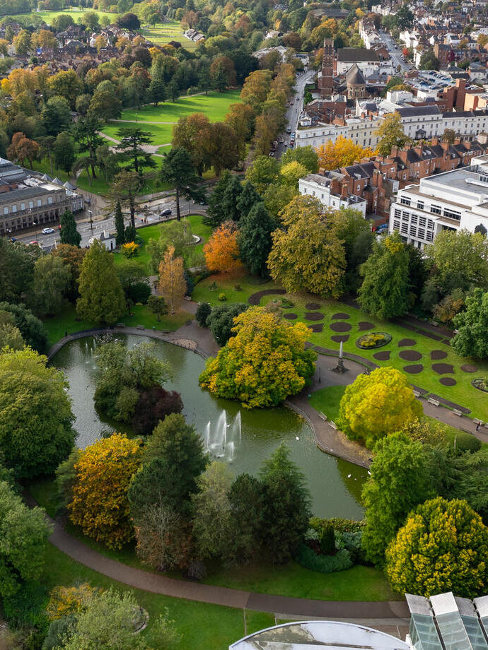 Aerial view of parks and gardens surrounded by trees with autumn foliage