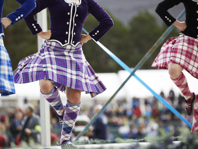 Drei Mädchen in Kilts tanzen schottische Tänze auf der Bühne