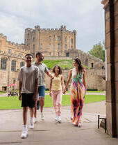 Family walking through an arch in the grounds of a cathedral