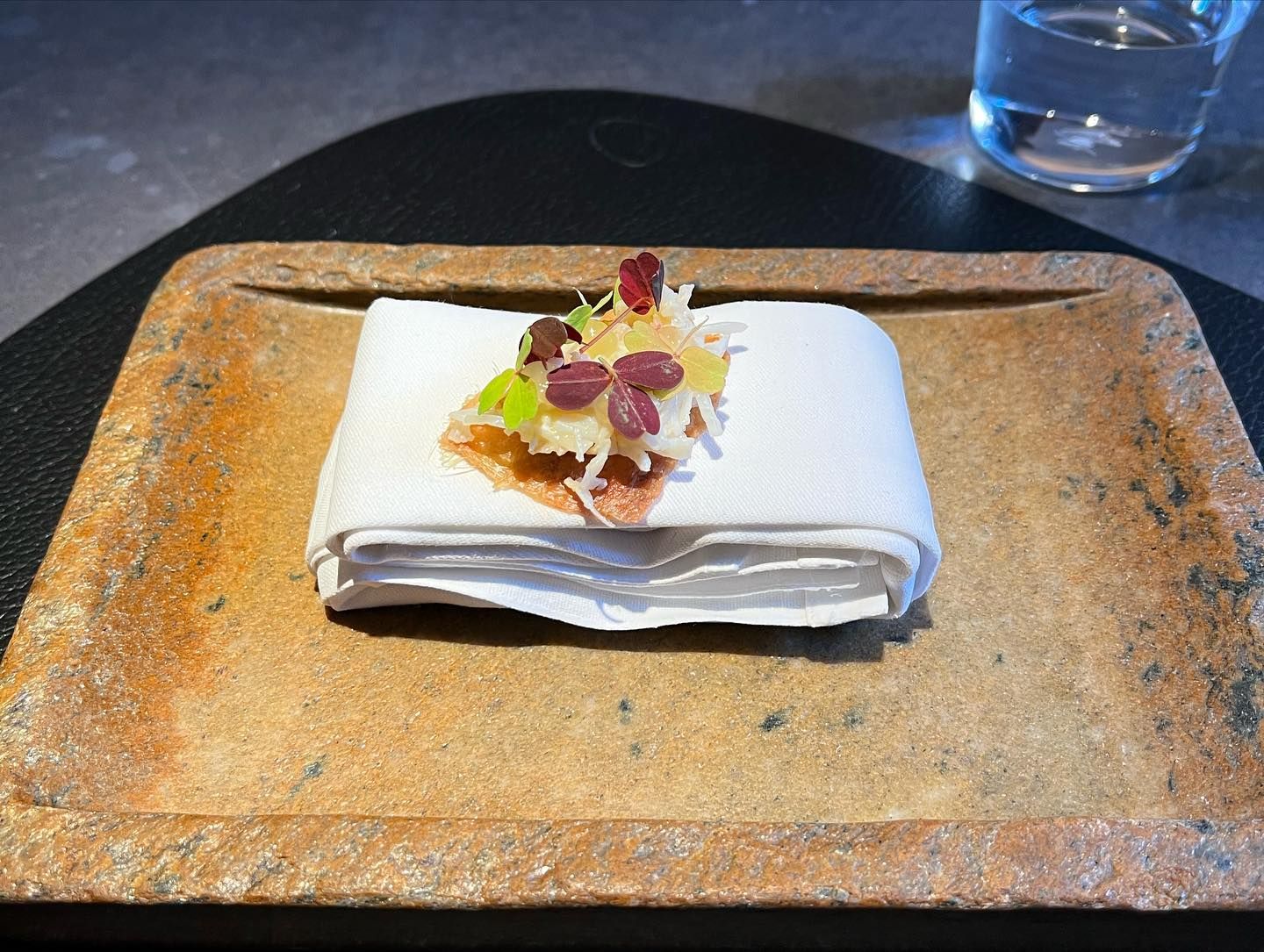 A plate of prepared food sitting on a table in Aulis restaurant, London