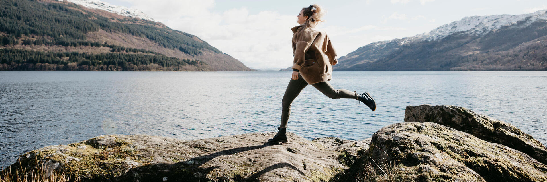 UK, Scotland, young woman running at Loch Lomond