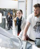 A man and a woman playing with an exhibit at Techniquest in Cardiff