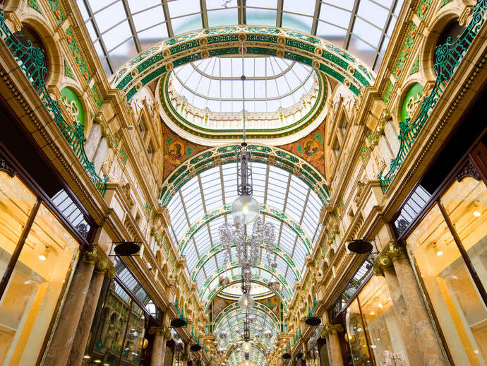 A majestic shopping arcade with ornate domed glass ceiling.
