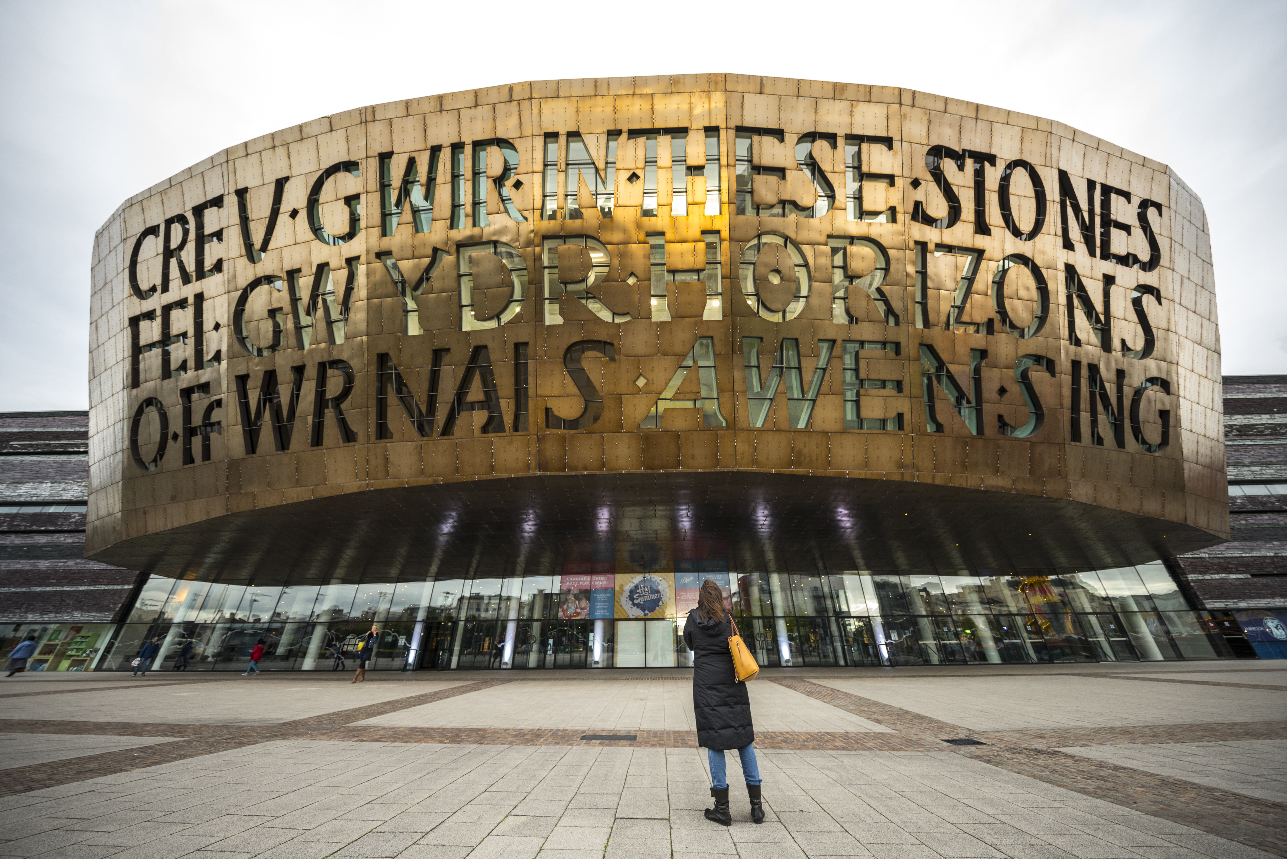 Person looking up at the front of a bronze building