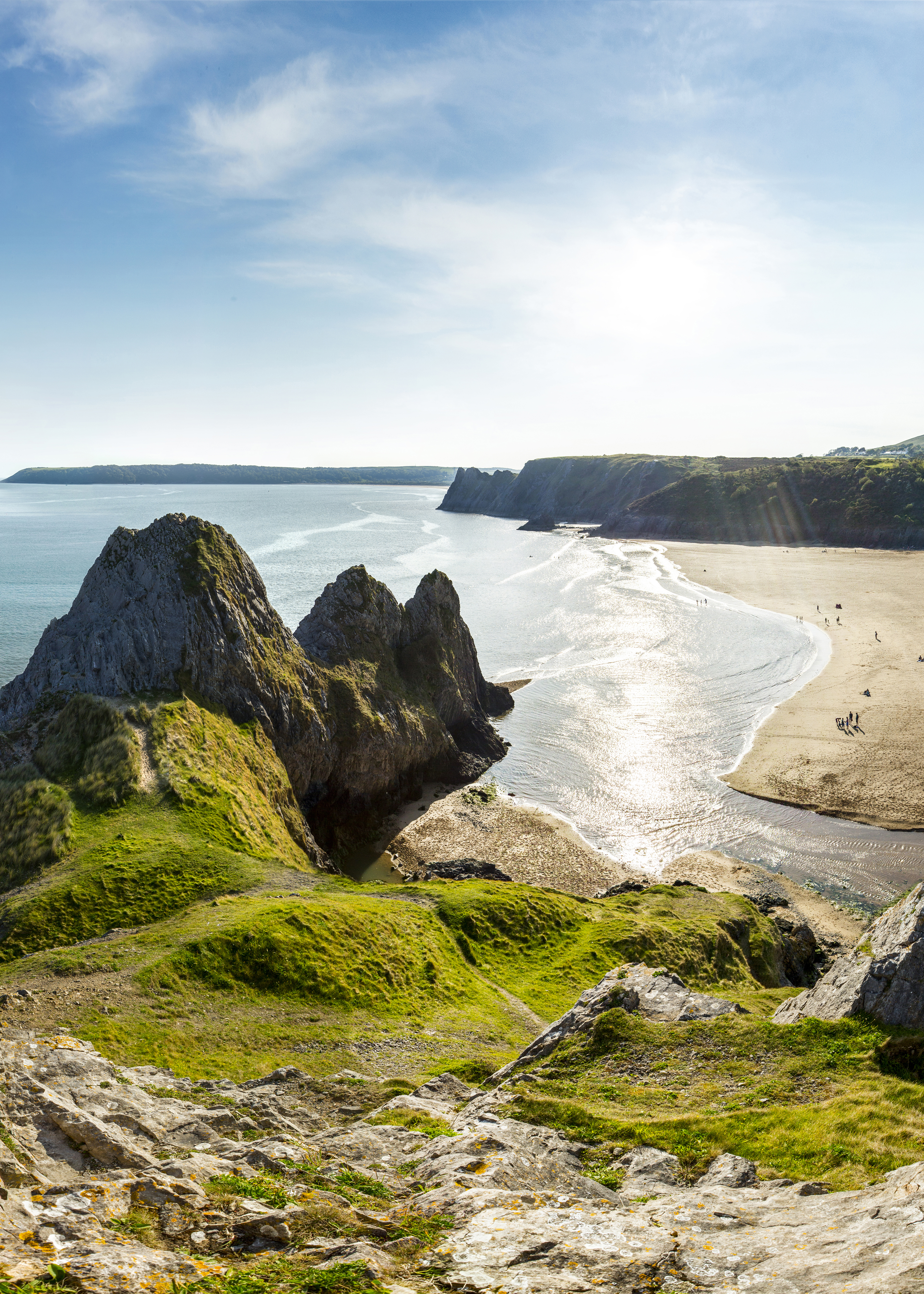 Coastline with a sandy beach and rocky peninsula.