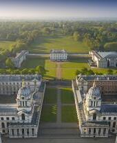 Aerial view of a massive mansion and manicured gardens.