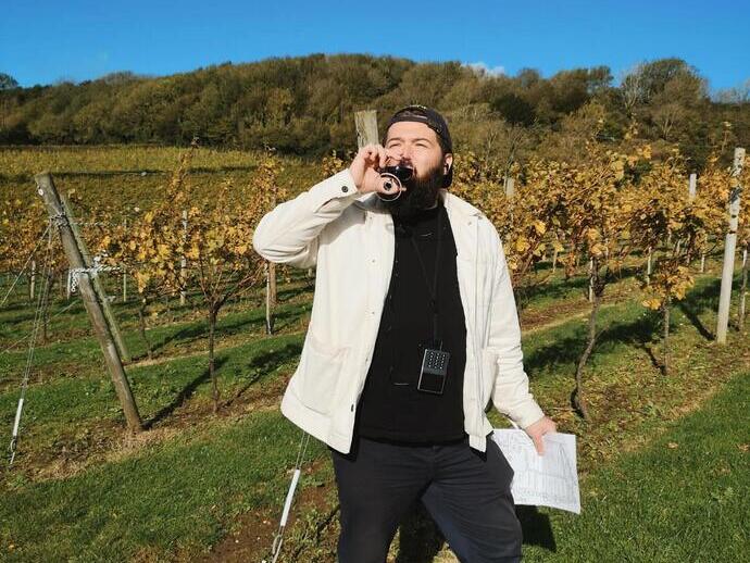 Un uomo che si gode un drink all'Adgestone Vineyard