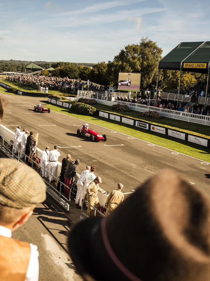 People in a grandstand watching a vintage sports car race