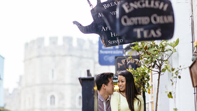 Pareja en una calle cerca de unas teterías y un castillo al fondo.