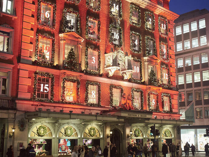 A crowd of people on the street outside a department store at night
