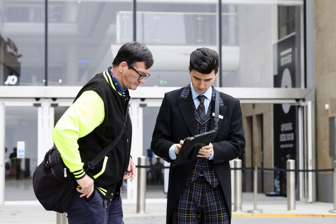 Concierge checking in guest outside building