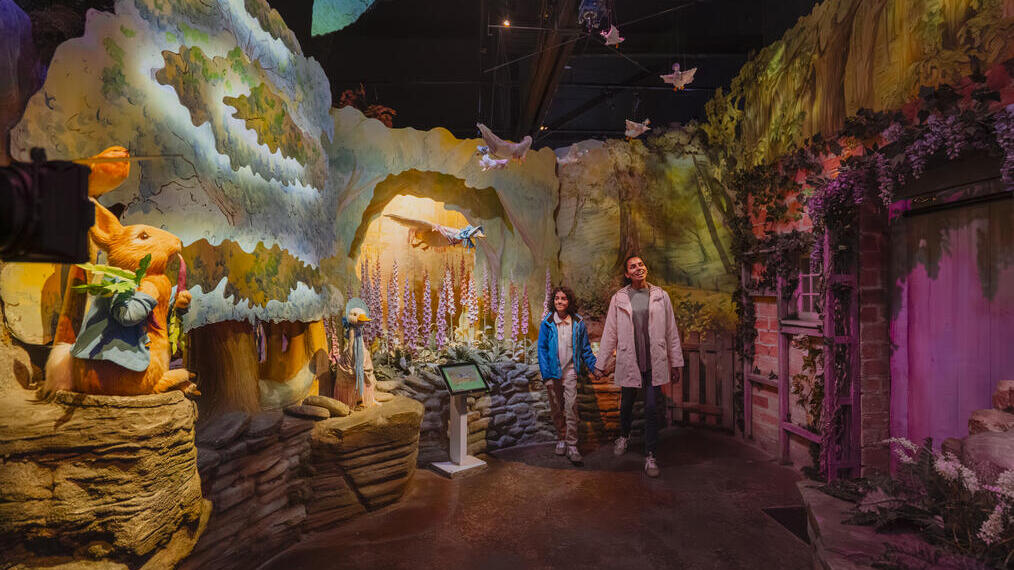Interactive exhibit with forest scenery, animal characters, and visitors, inspired by children's storybooks and woodland themes.