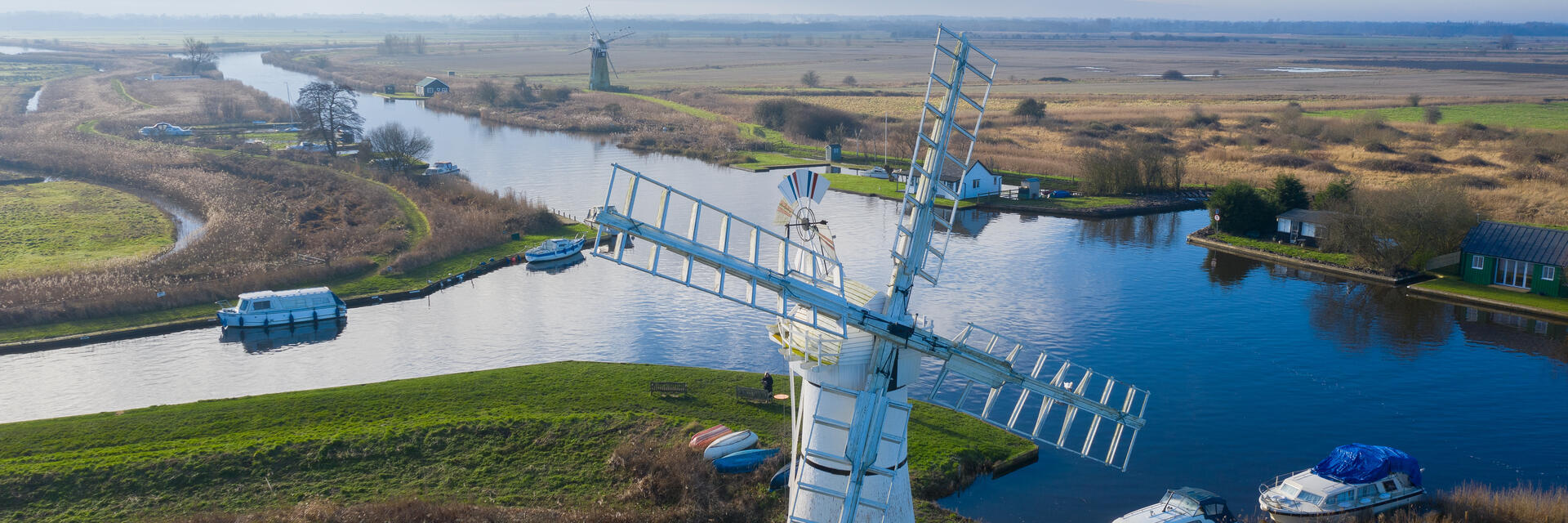 Luftaufnahme einer Windmühle und der umliegenden Weiden und Kanäle