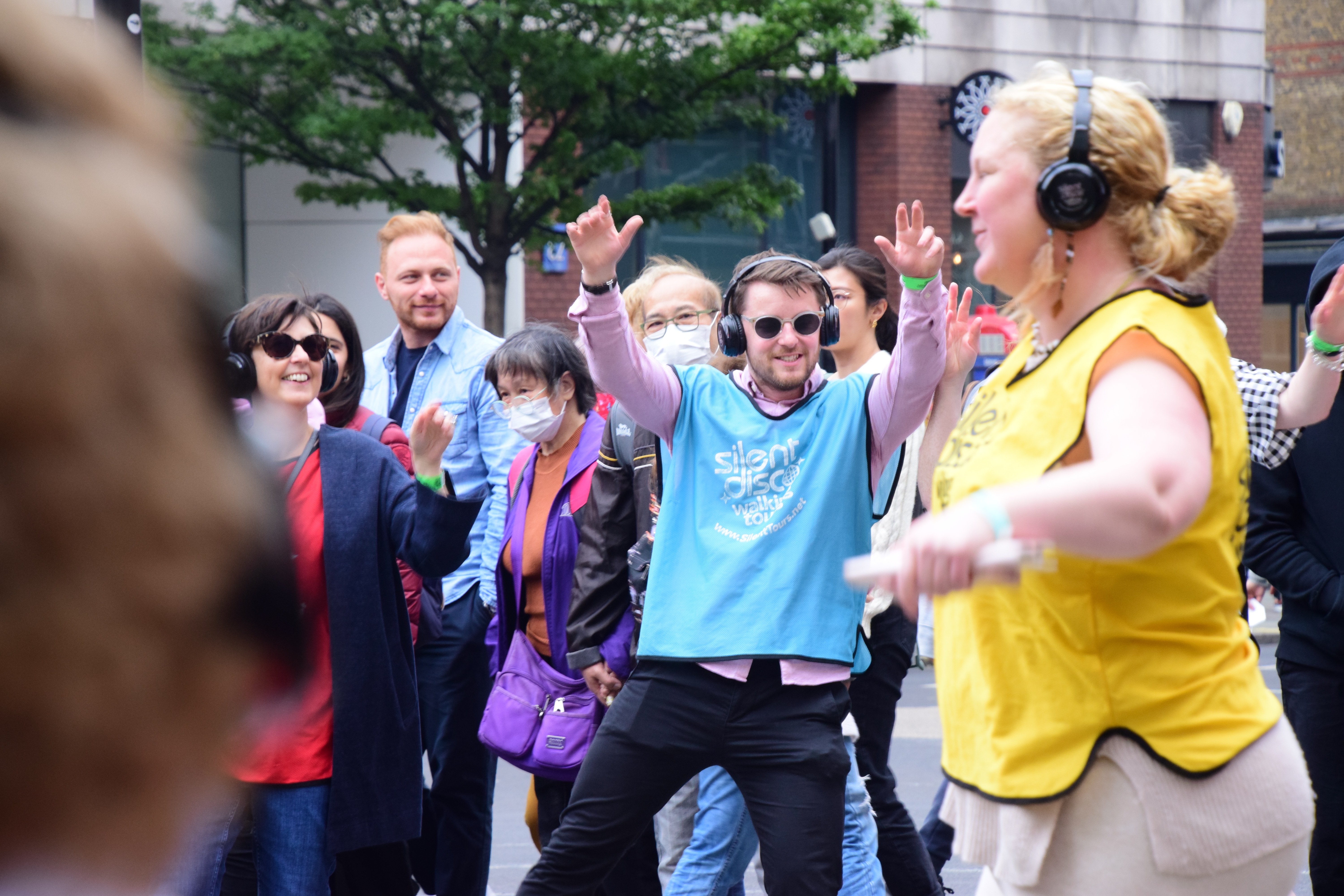 A group of people on an outdoor Silent Disco in London's West End
