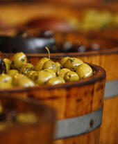 Buckets of olives on display at a market.