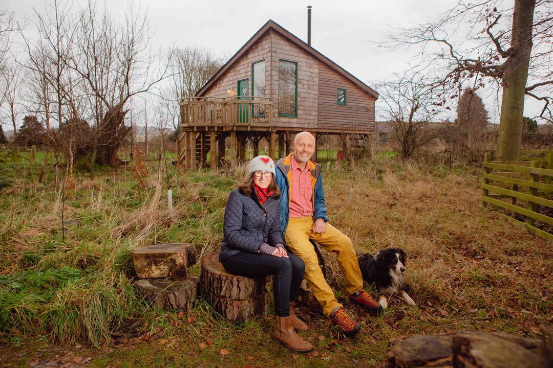 Man and woman sitting in front of cottage