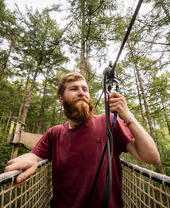 Mann, der an einem Sicherheitsseil befestigt ist – Go Ape Dalby Forest