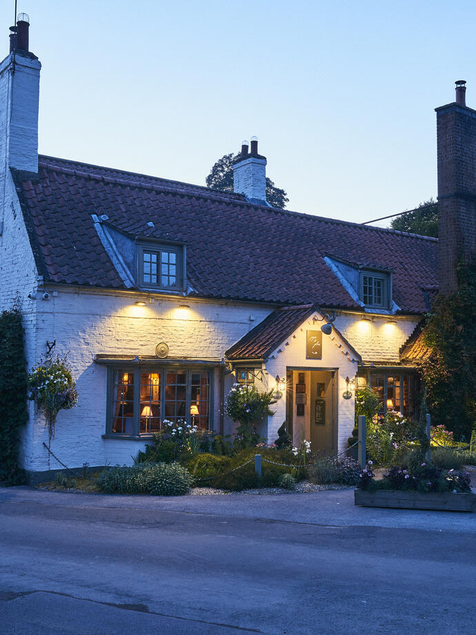 View of white inn, dimly lit in the evening