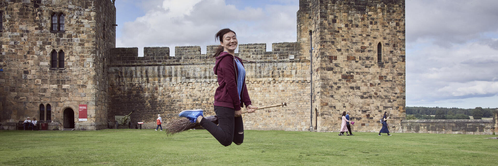 Femme sur un balai devant un château