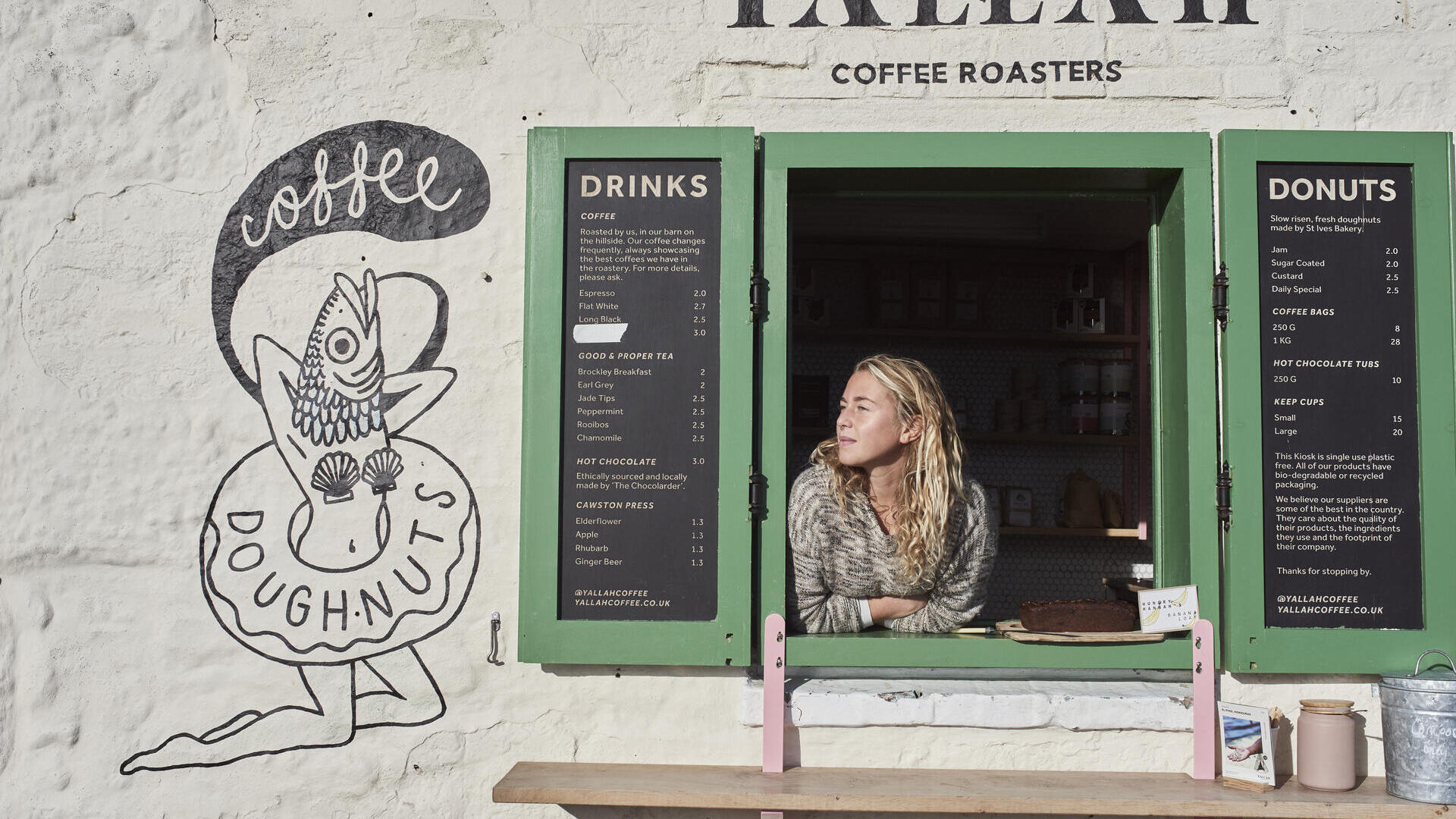 Frau, die durch das Fenster eines Cafés schaut