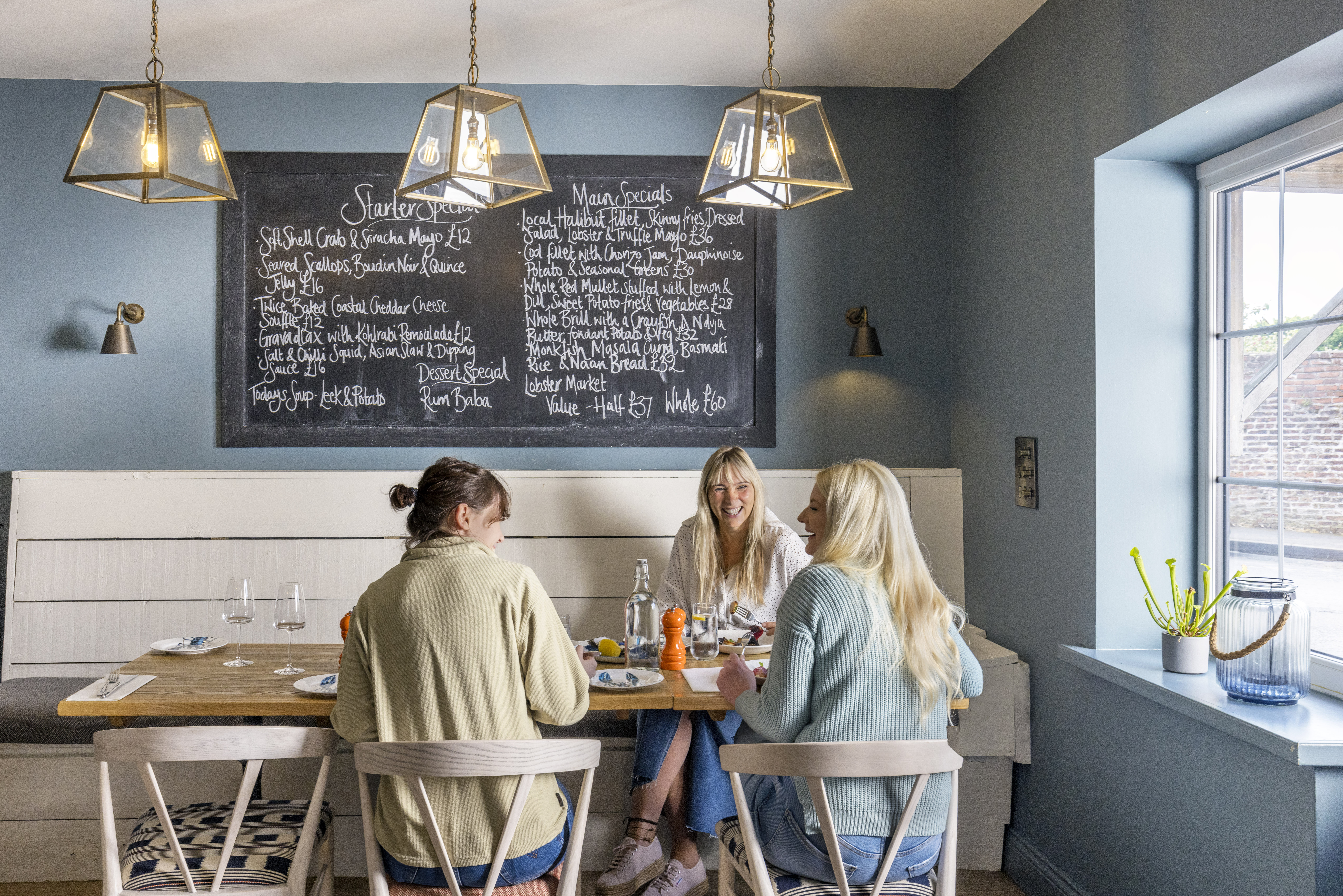 Three women eat lunch inside a restaurant