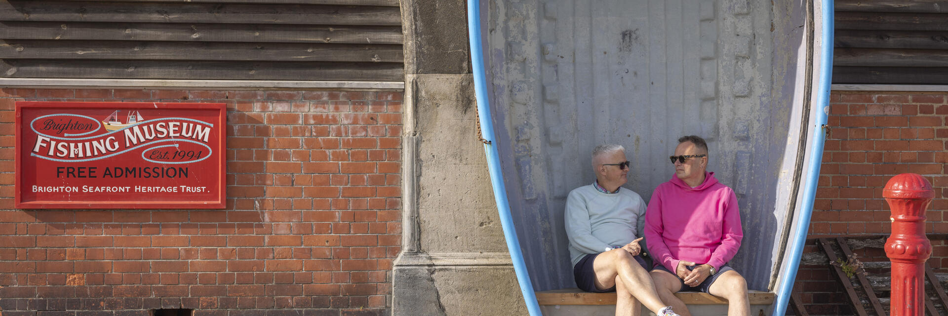 Zwei Männer sitzen auf einer Bank, die aus einem Ruderboot gefertigt wurde