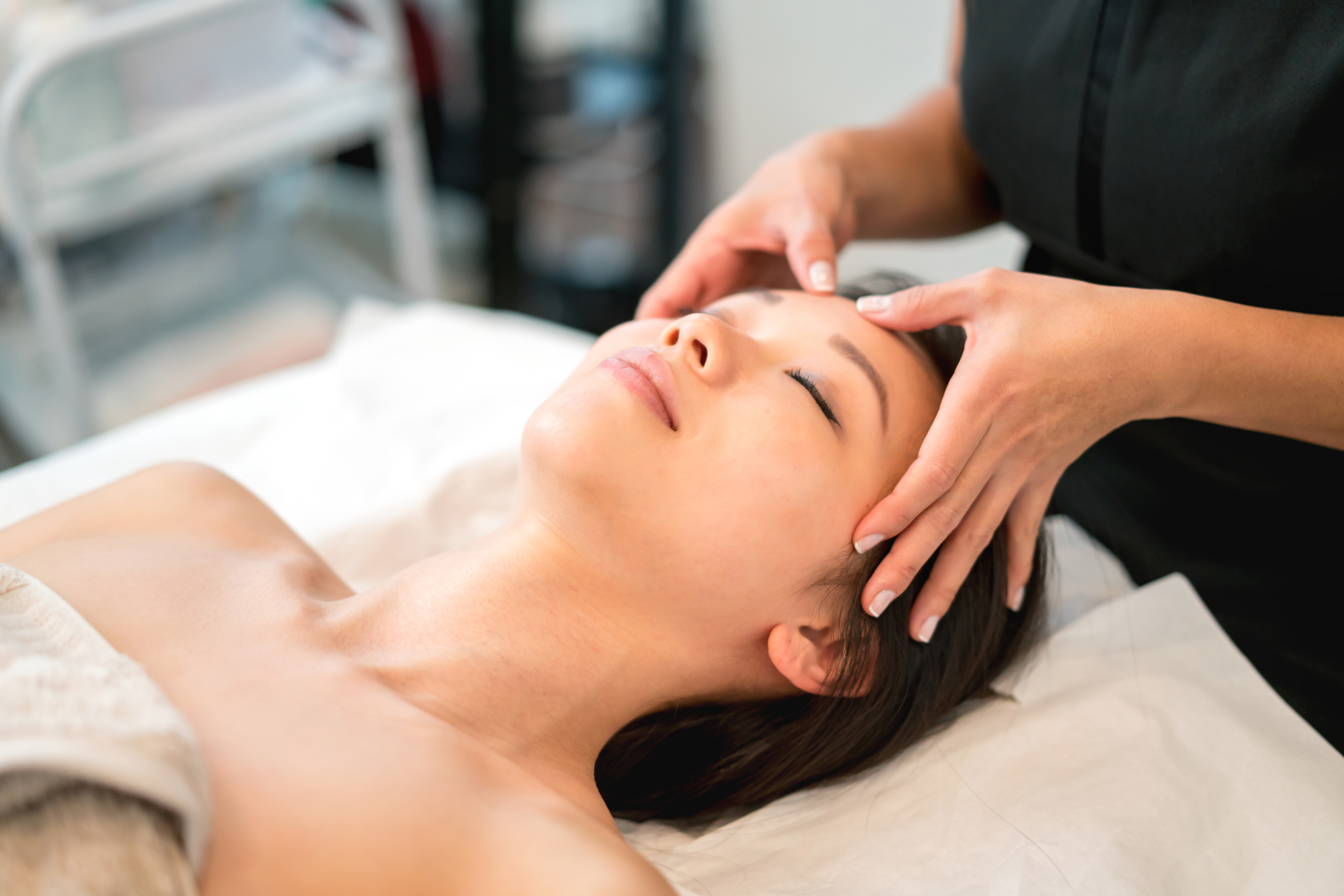 A woman getting a face massage at a hotel spa.