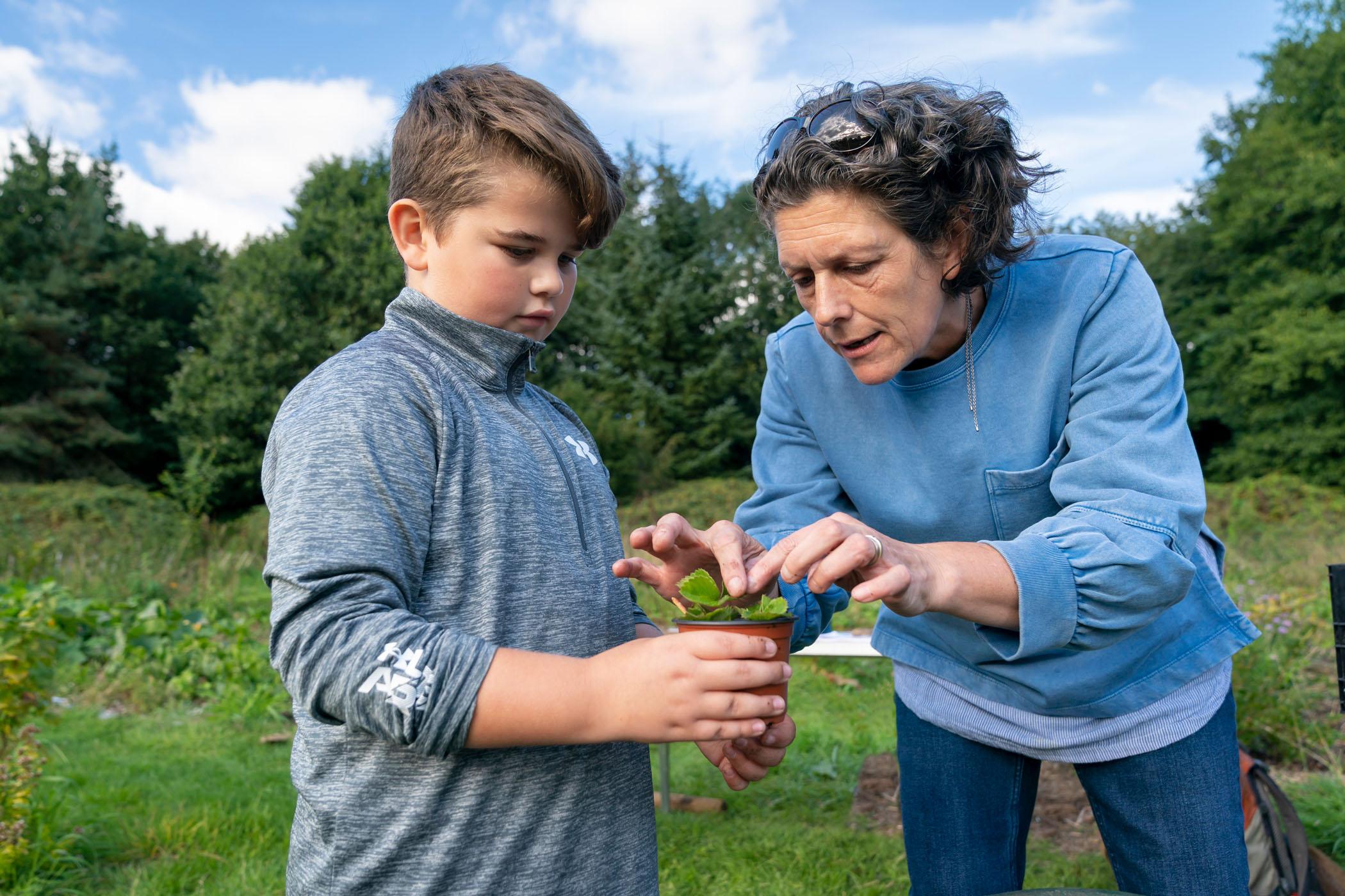 A woman and a child preparing a plant during growing activities at Northern Roots, Manchester