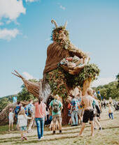 Group of people standing around large sculpture at a festival