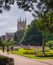 A cathedral amongst manicured gardens on a summer's day