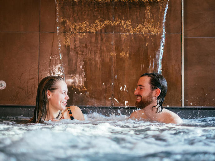 A couple in a pool as part of a spa treatment at Wave Garden Spa