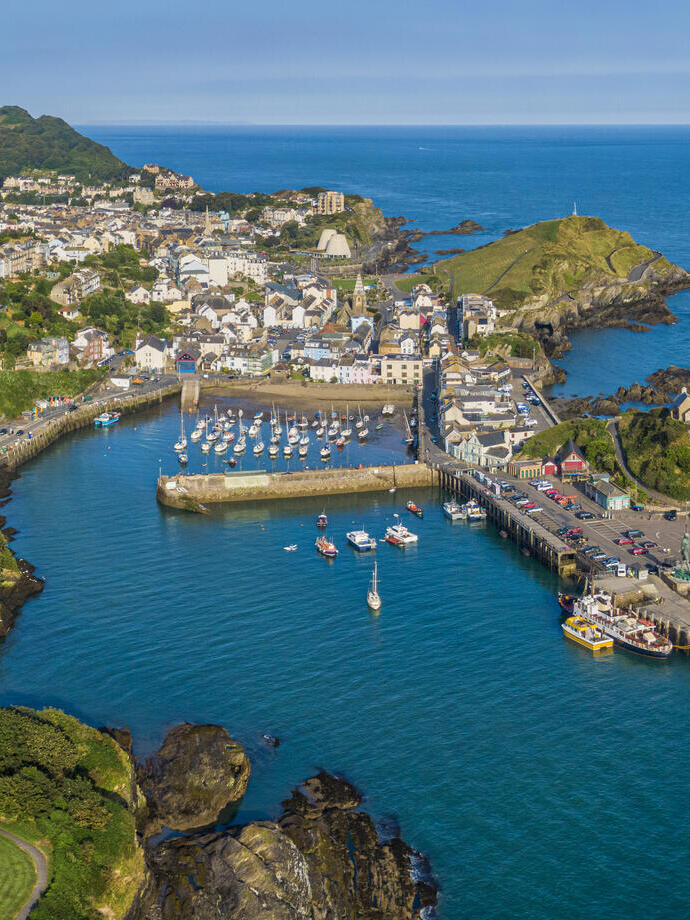 Aerial view of a coastal town with a harbour filled with boats