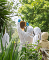 People in protective clothing taking part in a beekeeper experience.