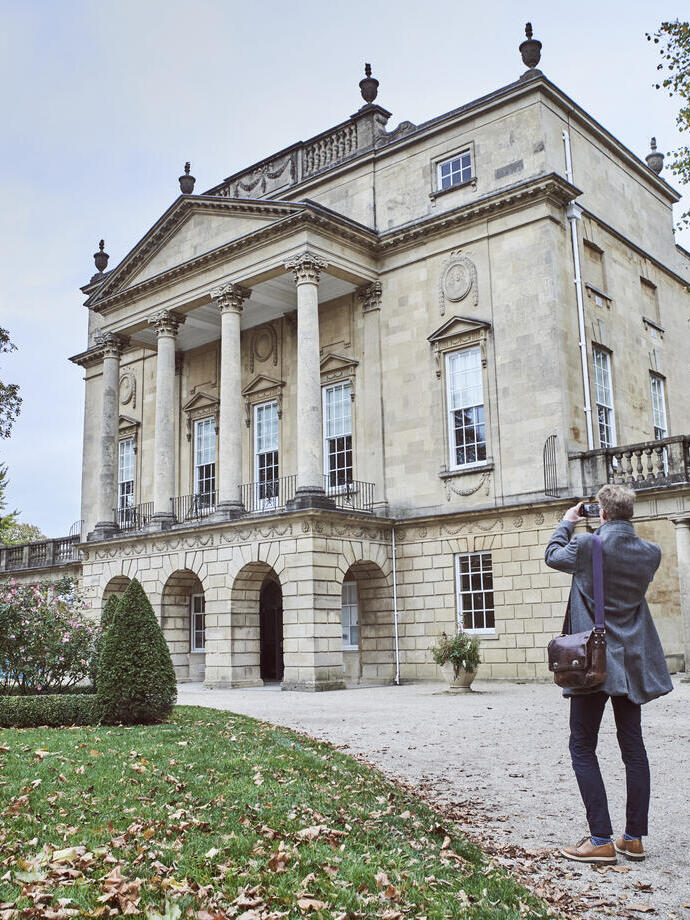 Rear view of man taking picture of The Holburne Museum, Bath, Somerset, England.