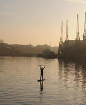 Una persona practicando paddle surf en medio del puerto de Bristol
