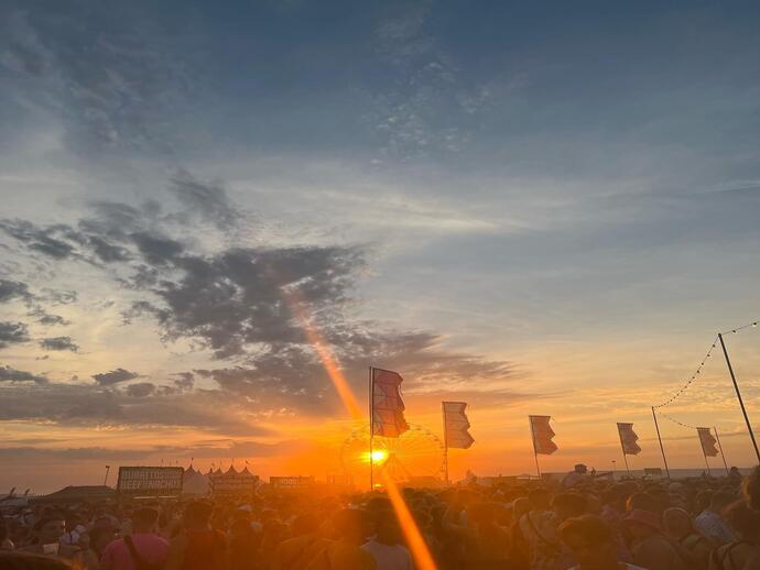 Sun setting over people at festival