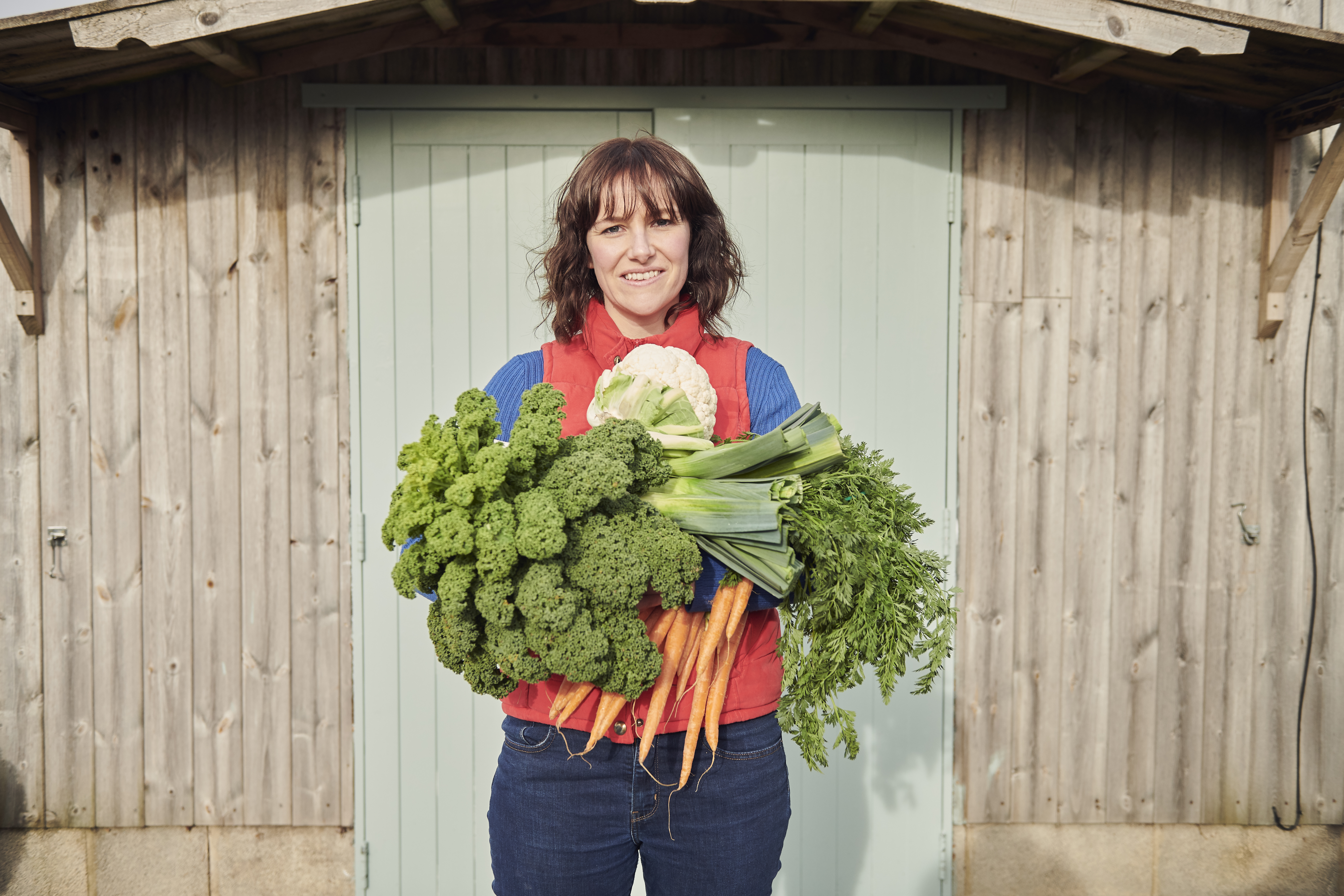 Woman holding a selection of fresh vegetables