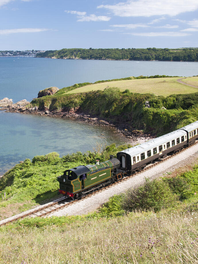 Steam train on a railway line following the coastline