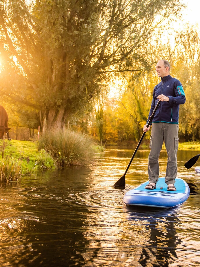Two people paddleboarding down the River Bure