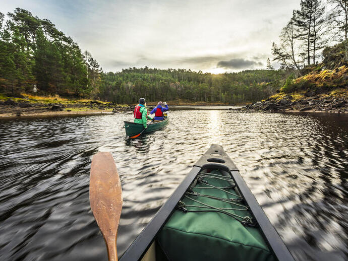Two women paddling canoes on water