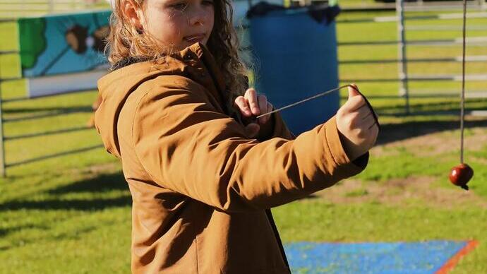 Un bambino che gioca con una castagna al World Conker Championships nel Northamptonshire