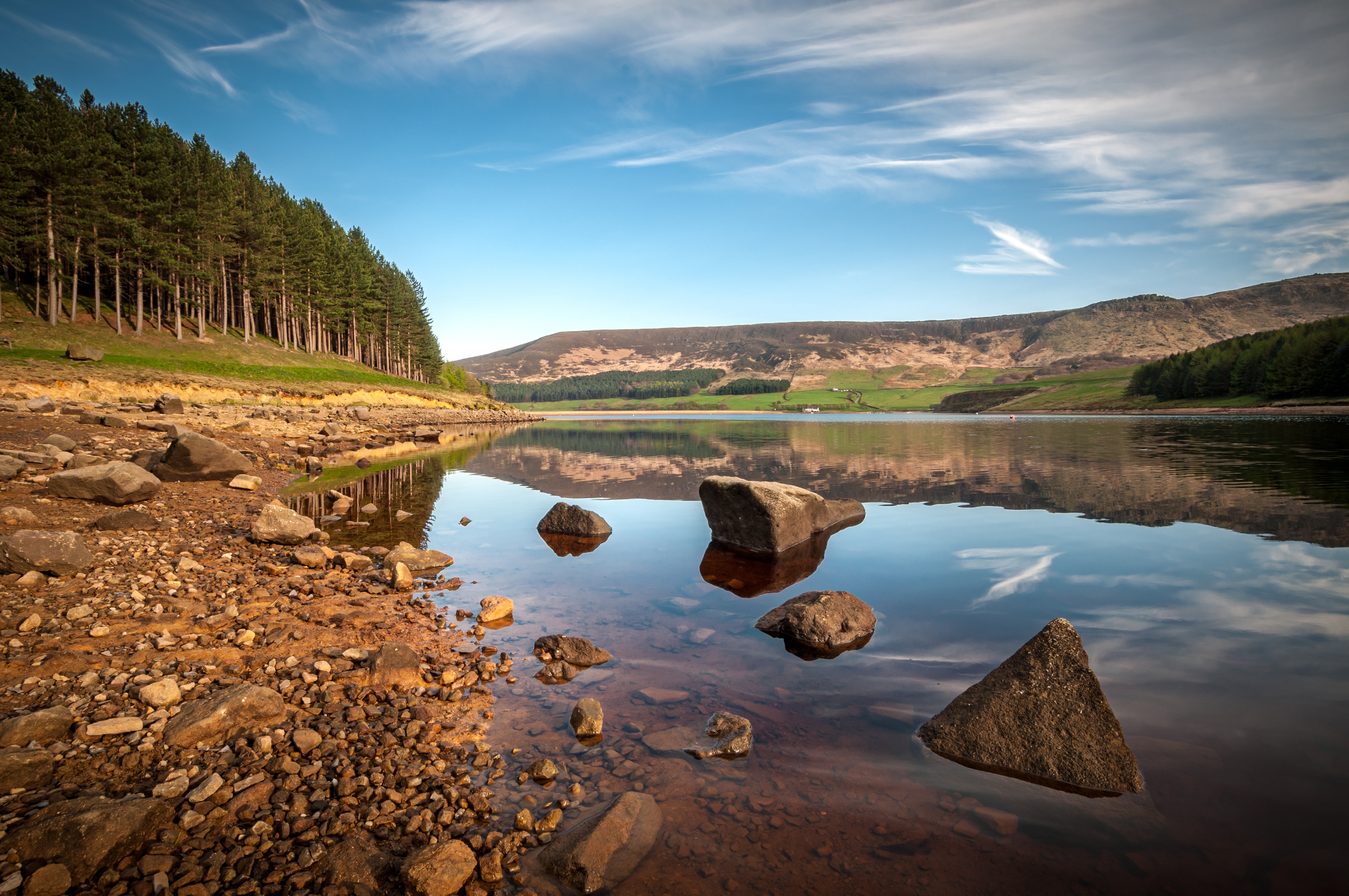 An outdoor shot of a reservoir with peaks in the background