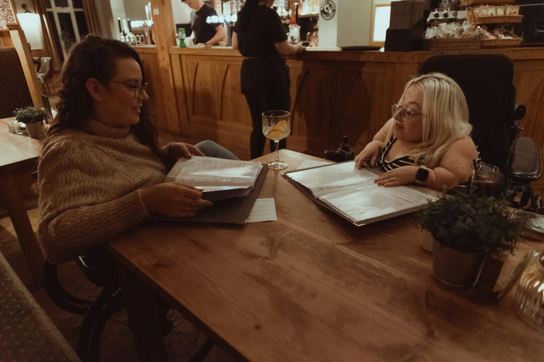 Two women browsing a menu at a restaurant