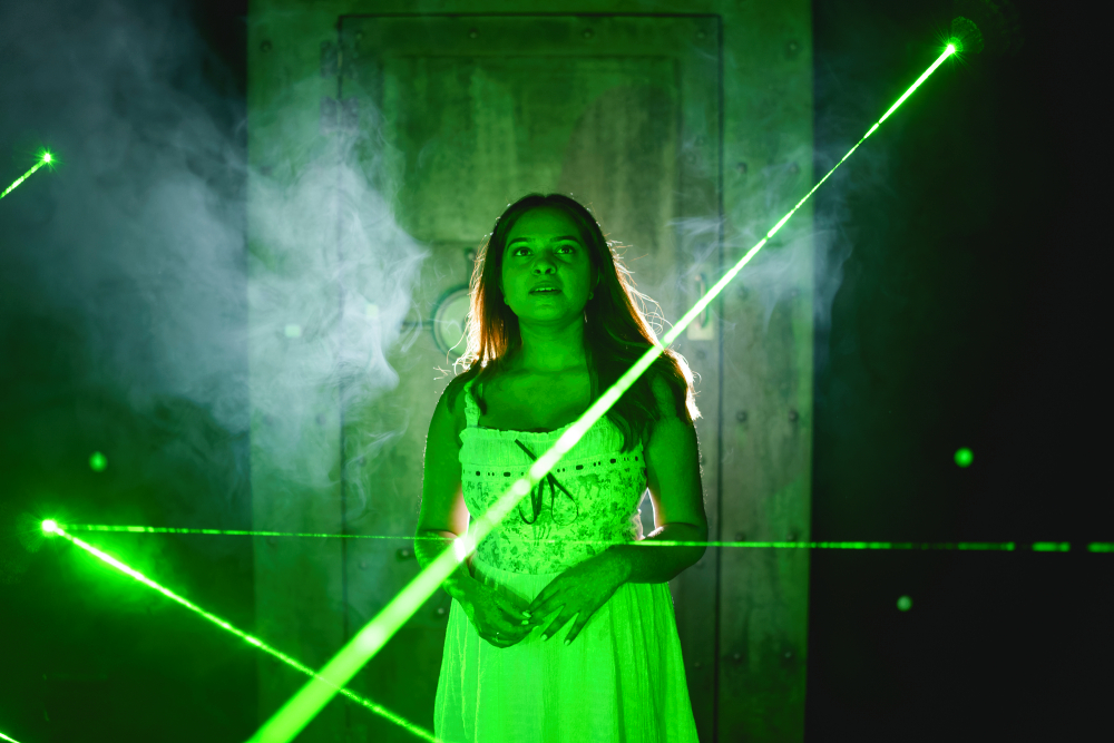 Una donna si diverte con l'esperienza laser interattiva di una escape room.